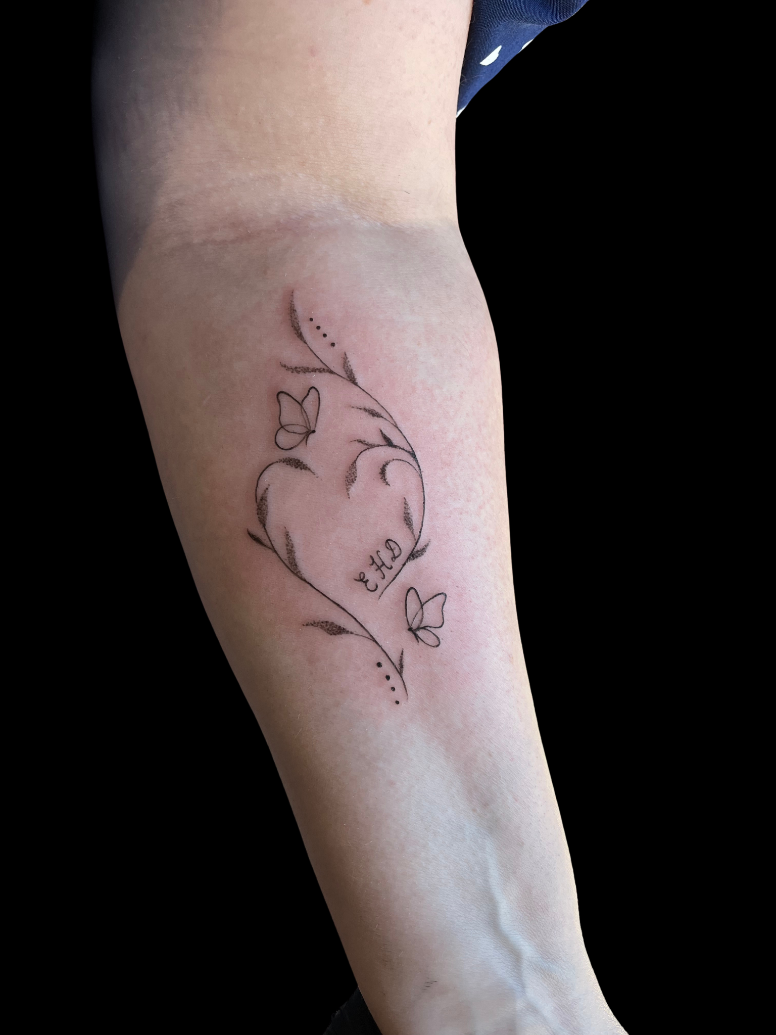 Tatouage cœur fleuri avec papillons en fine ligne sur avant-bras — Akamoa Tattoo Moustiers-Sainte-Marie